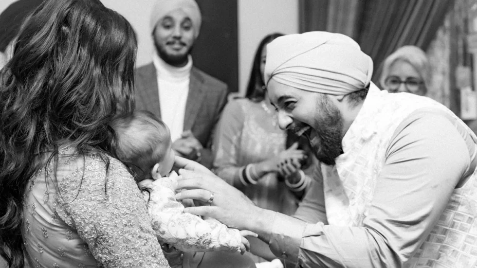 Man smiling at baby during family celebration