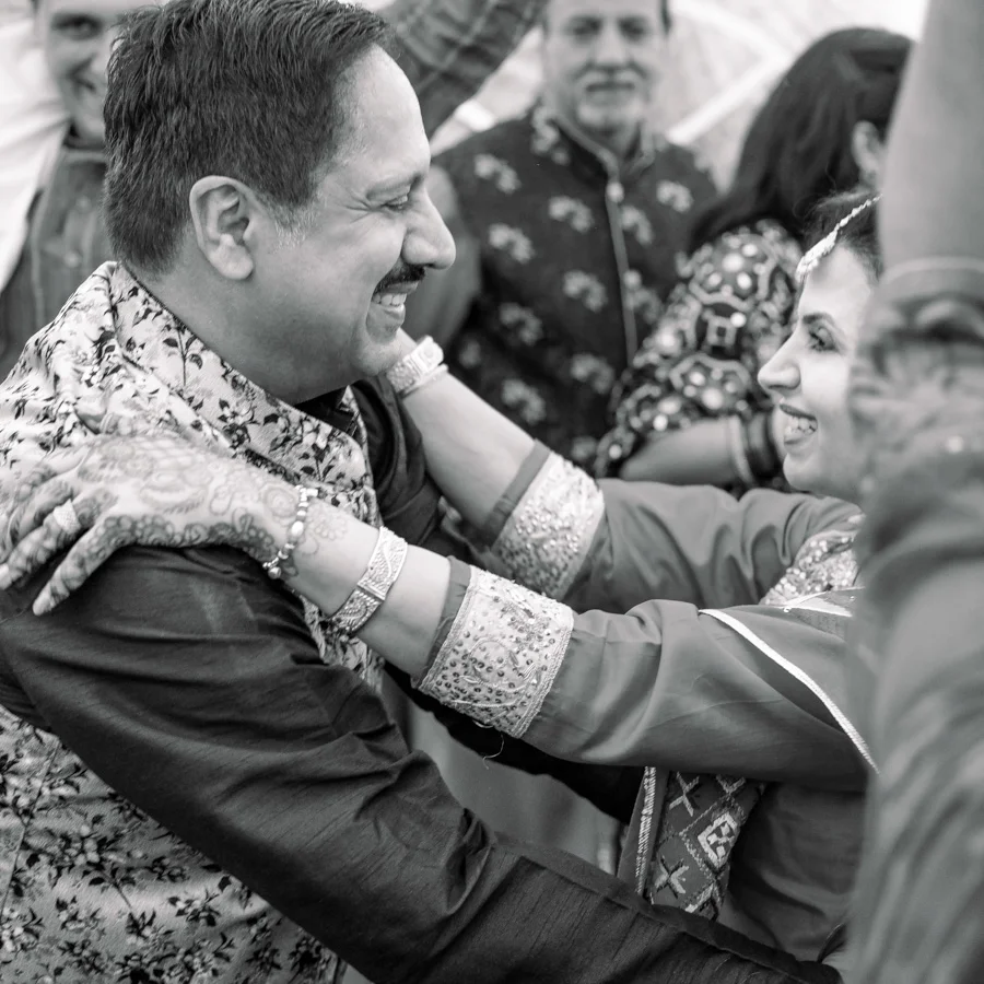 Emotional reunion captured between two guests at a celebratory event, photographed by Origin Story Studio