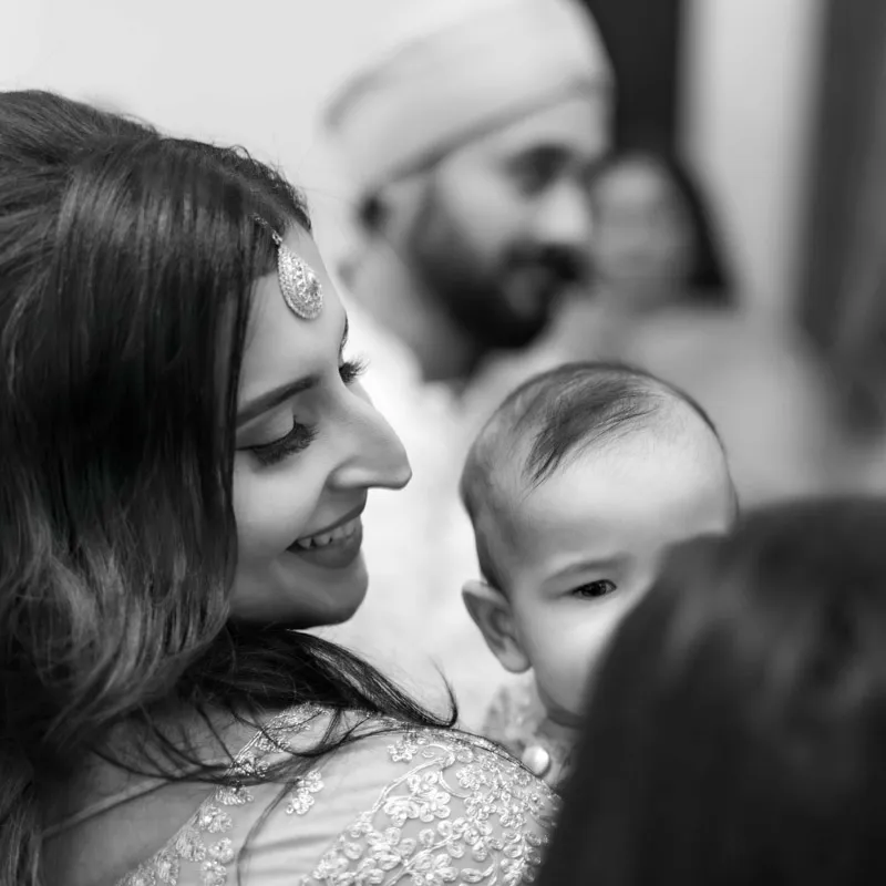 Smiling mother holds her baby during a Lohri celebration